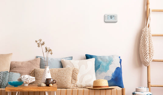 An X series thermostat is on a living room wall.