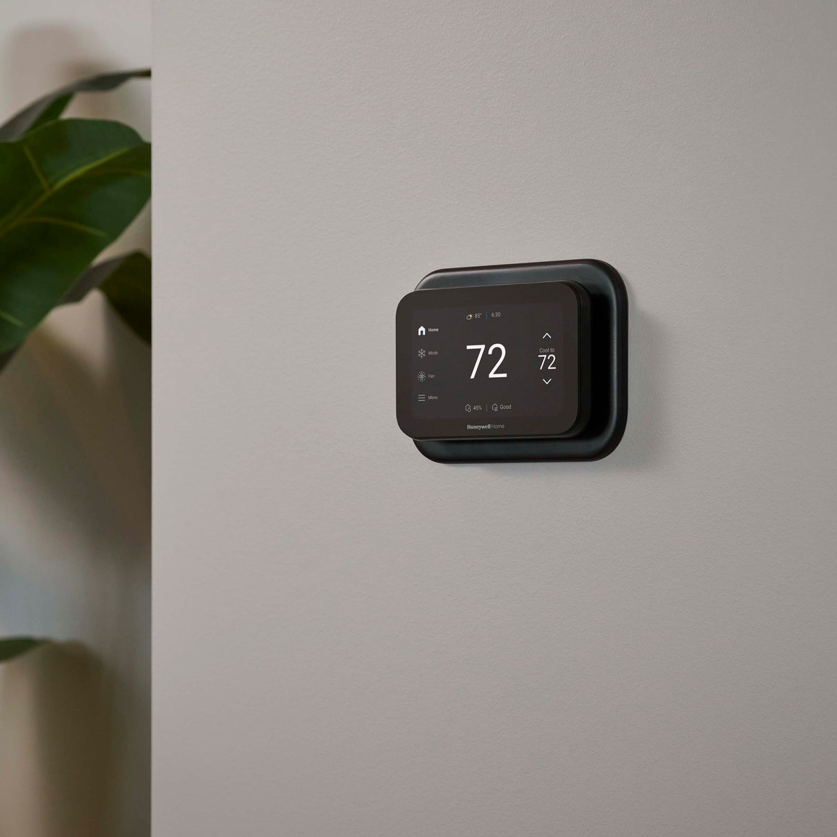 Thermostat Cover Plate Kit Black with thermostat installed in room