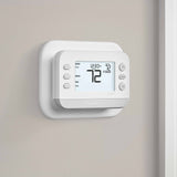 Thermostat Cover Plate Kit White with thermostat installed in room facing right